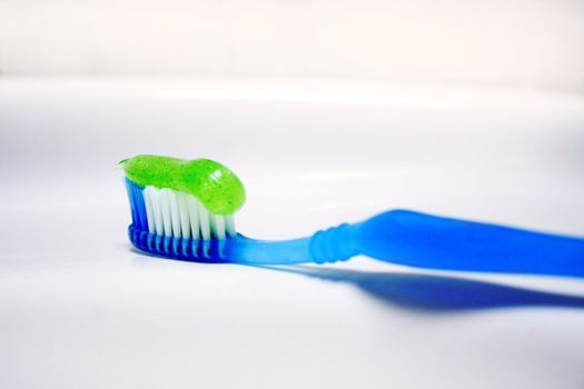 toothbrush with paste for cleaning teeth on background of the washstand