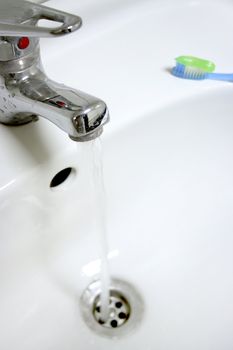 toothbrush with paste for cleaning teeth on background of the washstand