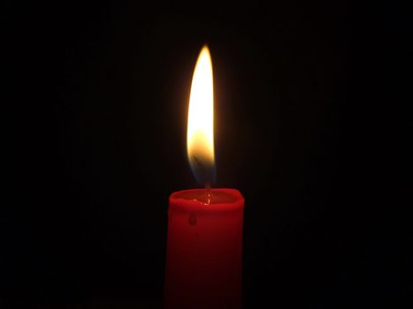 The red candle burning in full darkness