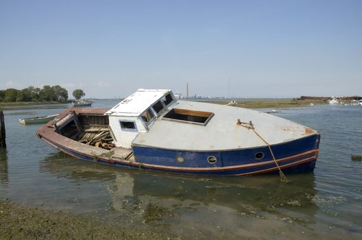 An abandoned small boat on the edge o f the river Medway