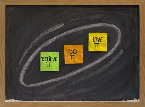 believe it, do it, live it - motivational concept on blackboard, colorsticky notes and white chalk drawing