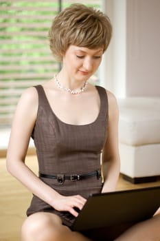 young woman working on a laptop, indoors, shallow DOF