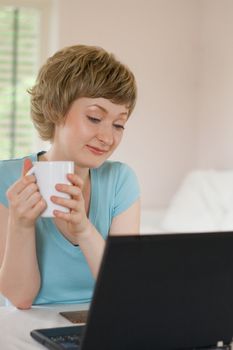 young woman working on a laptop, indoors, shallow DOF