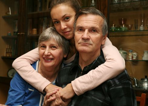The grand daughter embraces the grandmother and the grandfather