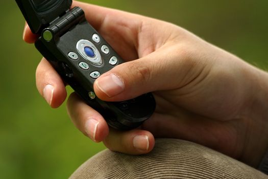The image of the man's hand pressing on the buttons of the mobile phone