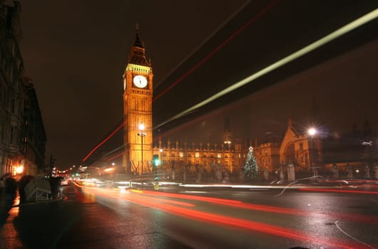 London. Big Ben at night with trails of light of passing traffic