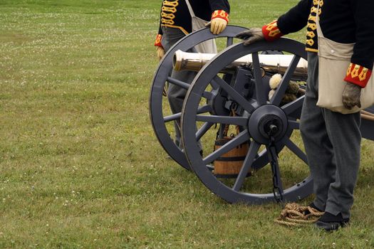 Soldiers in the uniform of the XIX century with a canon during a historical reenactment.