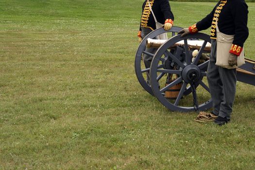 Soldiers in the uniform of the XIX century with a canon during a historical reenactment.