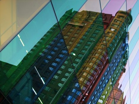 Colorful glass panels reflect a building in the city center.