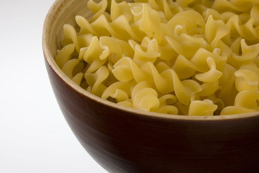 wooden, round bowl of fusilli pasta, white copy space