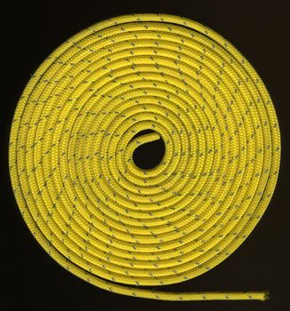 tight coils of yellow, nylon rope with a silver reflective thread on black