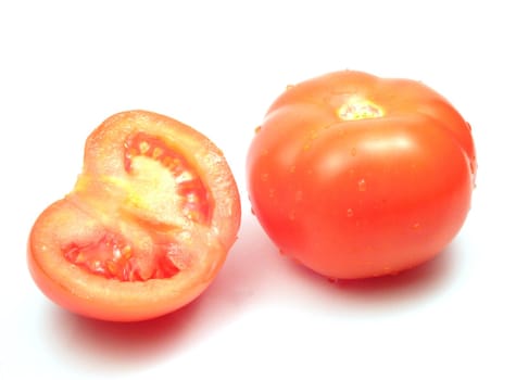 Fresh tomatoes, one cut in half, isolated on white