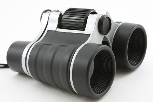 Black modern binoculars, laying flat view, isolated on white