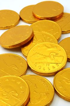 Chocolate gold coins, scattered on white background