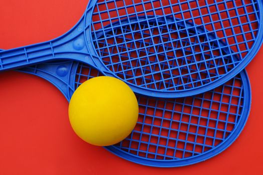 Two toy rackets and yellow ball