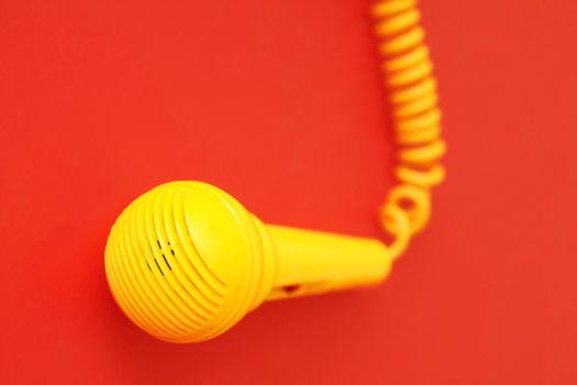 A yellow microphone on red