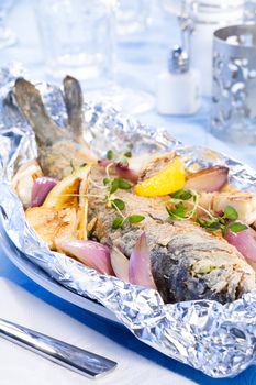 Trout baked with onion and lemon in foil