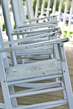 Some white rocking chairs waiting for customers. 