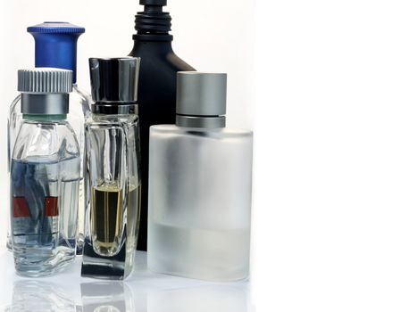 mixed colour fragrance bottles against a white background with reflection
