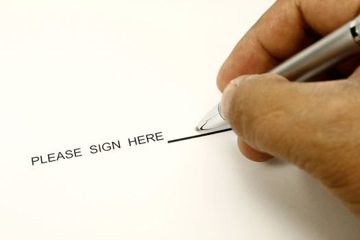 man hand holding a pen writing his signature
