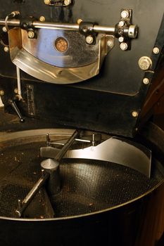 A large coffee roaster, just before the beans are extracted and slowly stirred in the cooling cylinder.
