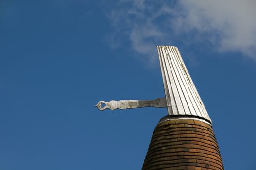 An oast house roof with a blue sky