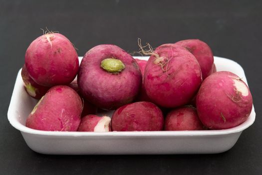 Some garden radishes on a black background