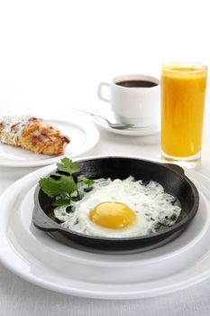 Fried eggs in frying pan, juice and coffee