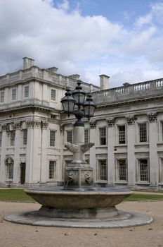 A fountain with a large georgian  building