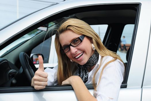 happy woman driving a new car