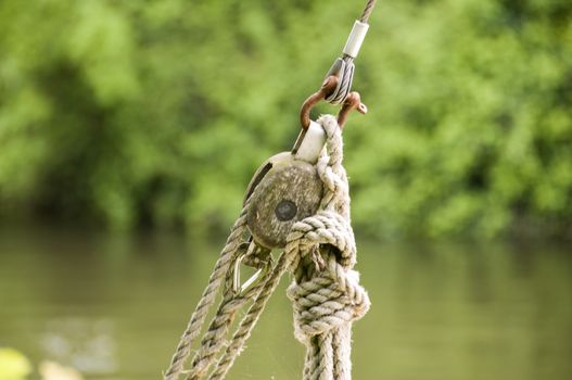 Detail of a rope pully with trees in the background