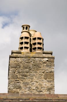 Some stone chimney pots on top of an old building