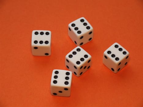 five dice all showing six on orange background