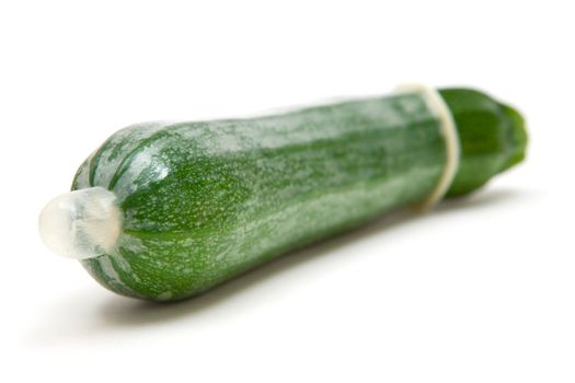 Condom and vegetable. Shallow depth of field. White background.