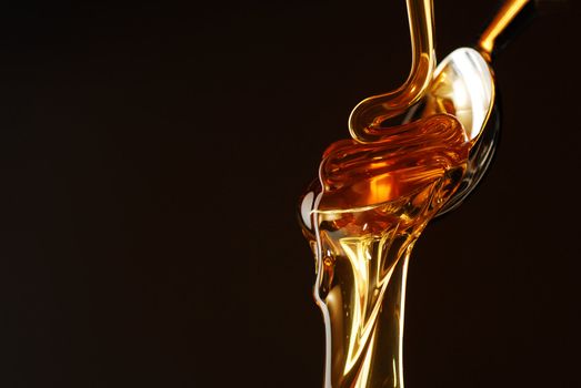Honey flowing out of the spoon stock photo