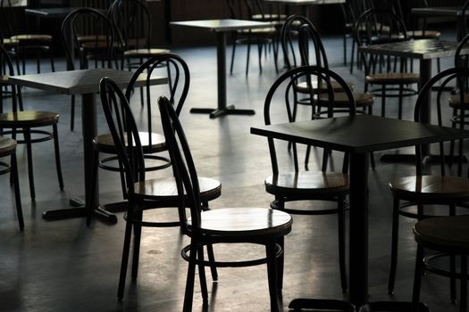 Tables and chairs in a cafeteria. Light coming from the window.