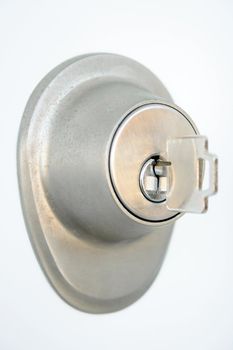 Close-up of metallic door lock with a key in the keyhole. Focus on the keyhole.
