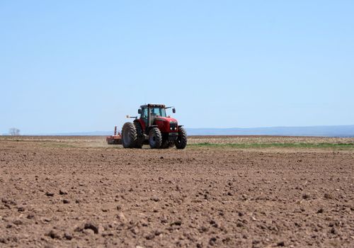 Farmer working on him tractor plowing land in spring.