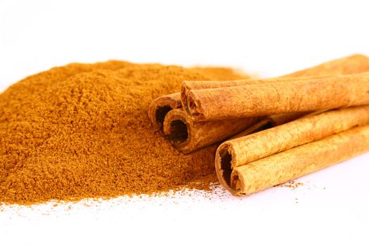 Sticks and powder of cinnamon reflected on the white background