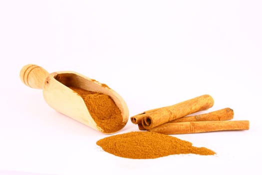 Sticks and powder of cinnamon reflected on the white background