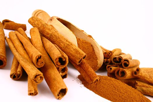 Sticks and powder of cinnamon reflected on the white background