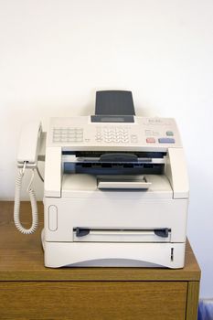A fax machine sitting on a table in the office - a must have tool for any business.