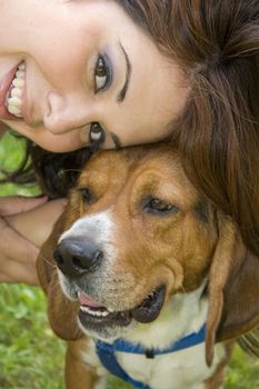 A pretty girl posing with her beagle dog.