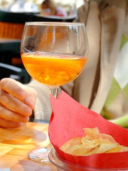 Hand holding a long drink glass during happy hour