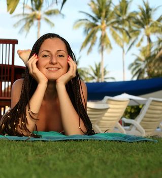 A beautiful young woman relaxing in the grass.