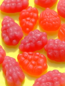 Fruit flavored candies on a yellow background
