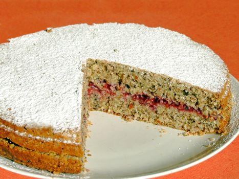 Homemade buckwheat cake with cranberry marmalade decorated with icing sugar
