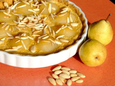 Close-up of a homemade tart Bourdaloue with pears, almond cream and vanilla custard and some ingredients besides