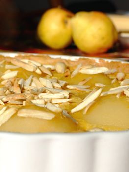 Close-up of a homemade tart Bourdaloue with pears, almond cream and vanilla custard and some ingredients besides
