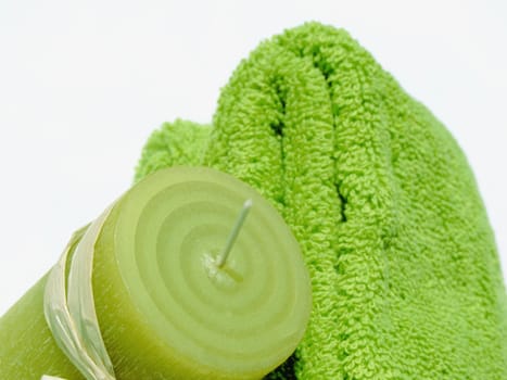 Two green towels and a green candle